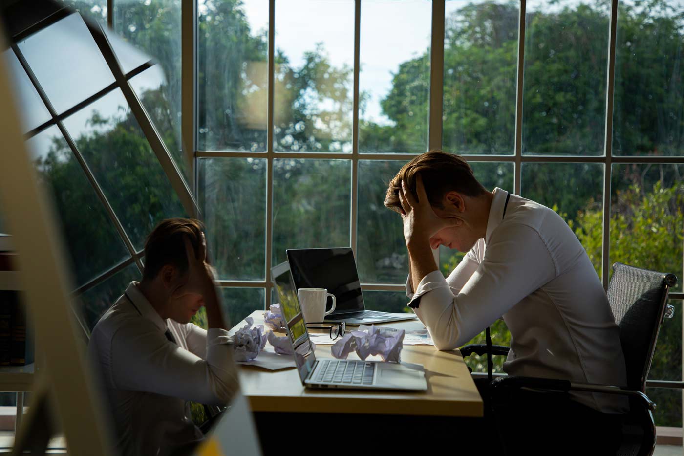 Frustrated man with head in his hand, while working from home.
