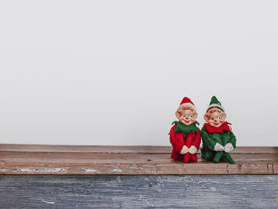 Two Santa assistants toys sitting next to each other