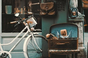 bike and open suitcase outside shop