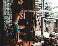 boy looking through telescope