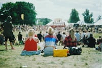 people sitting on grass at concert