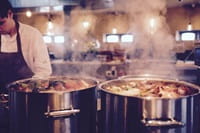 steaming cooking pots in restaurant kitchen