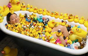 Charlotte Lee in bath of rubber ducks
