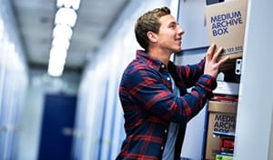 man putting boxes into storage locker