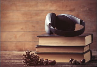 headphones resting on pile of books