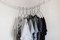 t-shirts hanging on wire hangers