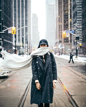 wearing scarf on blowy city street