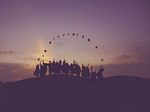 students silhouette on hill top 
