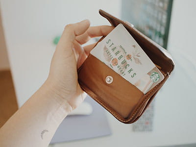 person holding brown leather coin purse