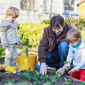 Father teaching children gardening