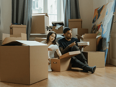 A couple surrounded by their moving boxes struggling with their move without using Access Self Storage's moving home checklist.