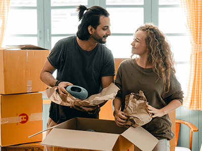 An image of a man and woman unpacking for our blog on things you need for a new house