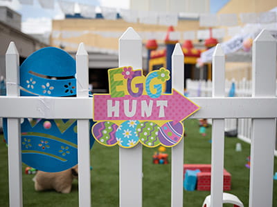 multicolored egg hunt decor on white wooden fence