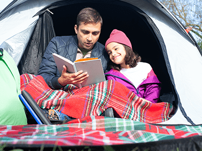 An Image of a father and daughter camping for our beginner camping checklist