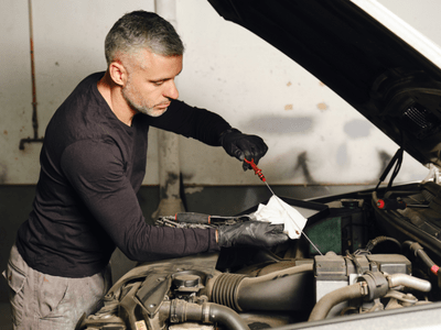 An image of someone changing car oil for our page on how to store a car long term