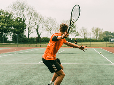 An image of a man playing tennis for our page on Wimbledon tennis courts