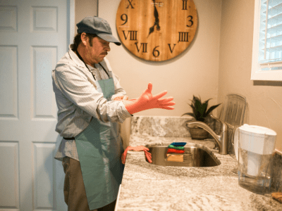 An image of a man putting on cleaning gloves for our kitchen cleaning checklist